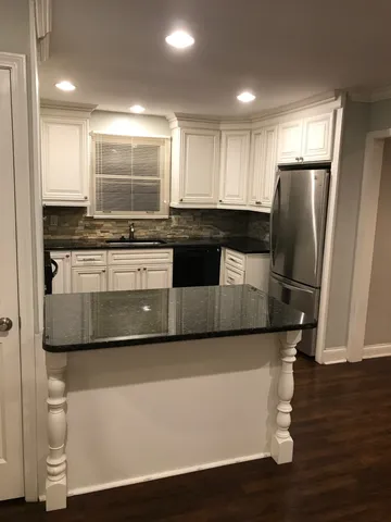 a kitchen with stainless steel appliances granite countertop a refrigerator a stove a sink and a microwave