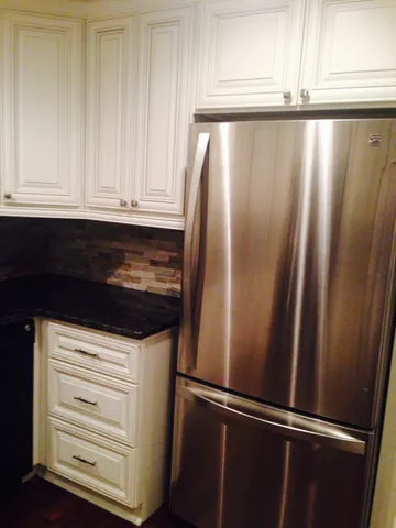 a close view of wooden cabinets and stainless steel appliances