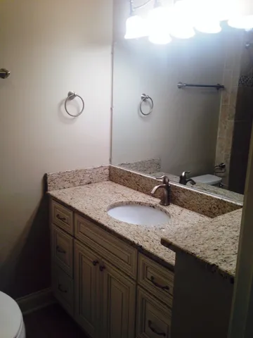 a bathroom with a granite countertop sink and a mirror