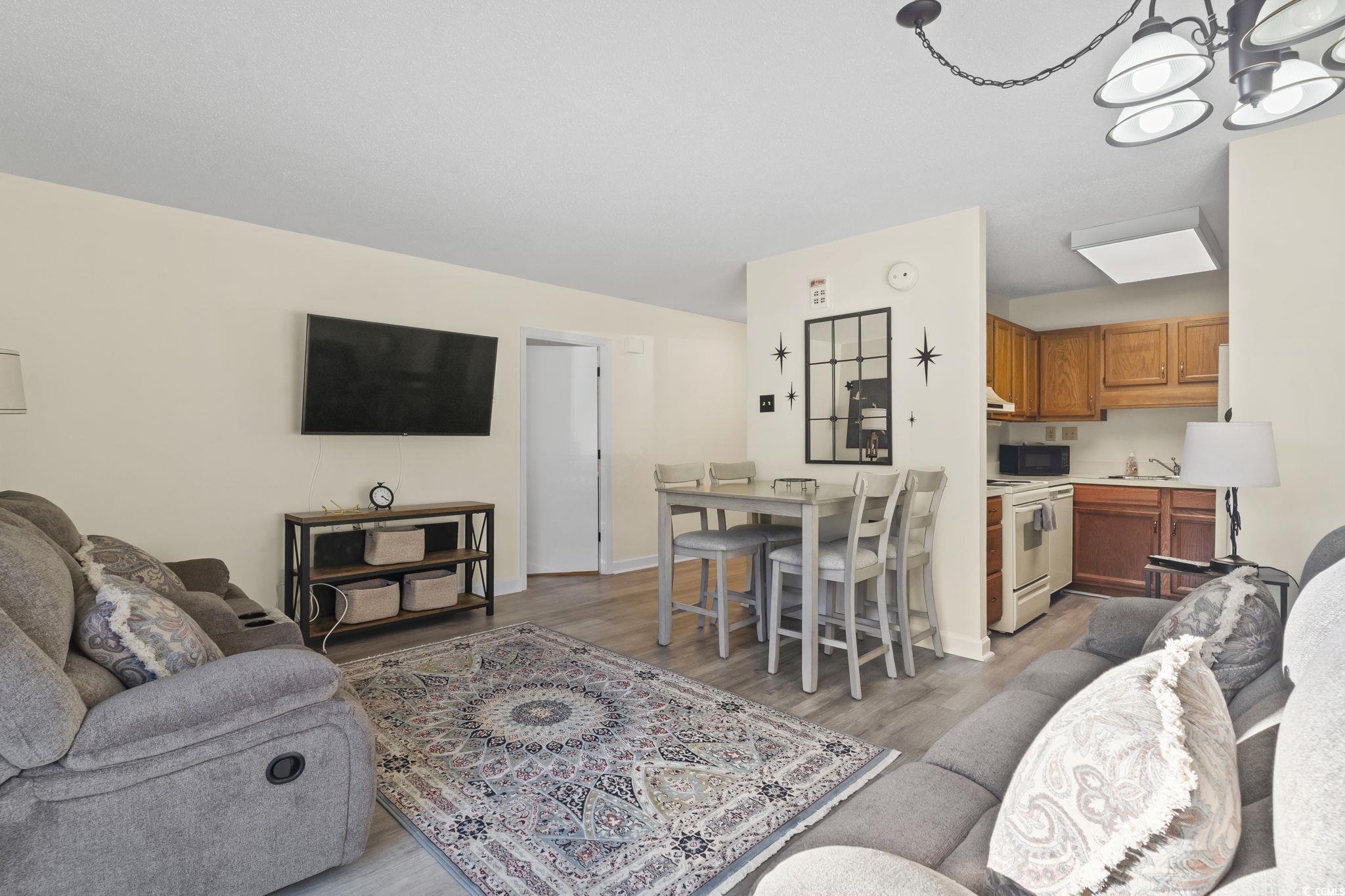 5001 Little River Road, Unit W106 Myrtle Beach, SC 29577 - Photo 3 of 28 Living area featuring light wood finished floors and a chandelier