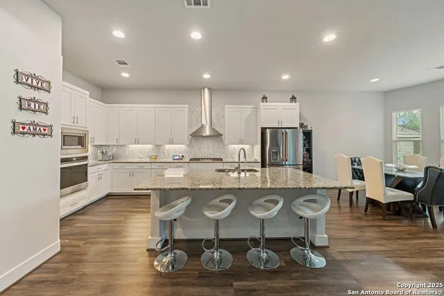 a large kitchen with a table and chairs in it
