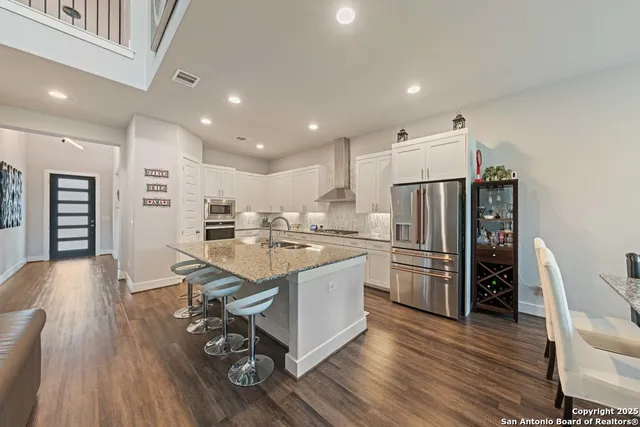 a kitchen with a sink appliances and wooden floor