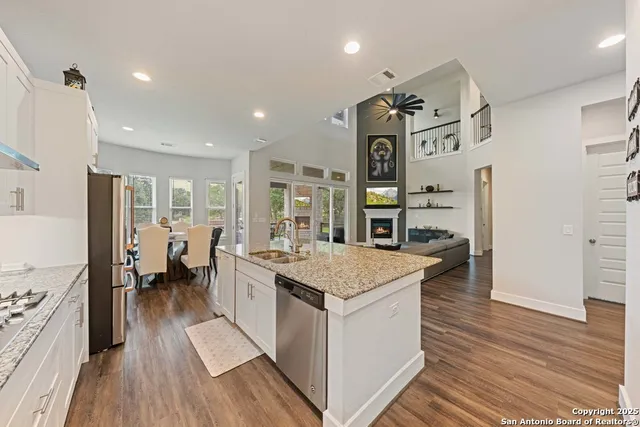a open kitchen with stainless steel appliances granite countertop a lot of counter space and wooden floors