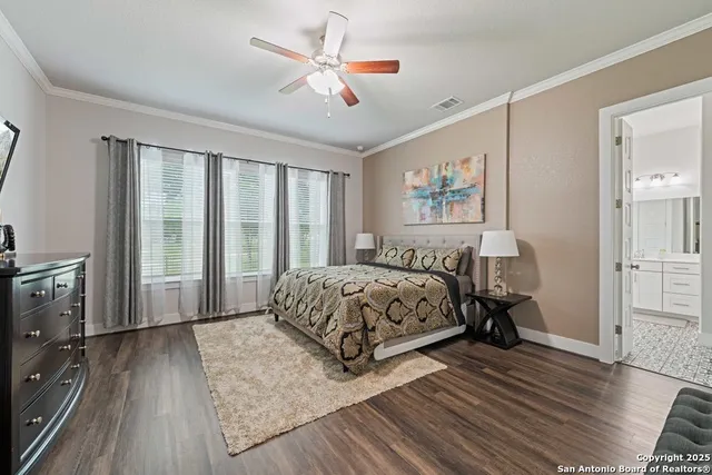 a bedroom with a large bed a flat tv screen and a dresser