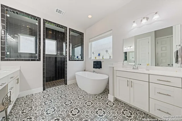 a spacious bathroom with a bathtub sink and mirror
