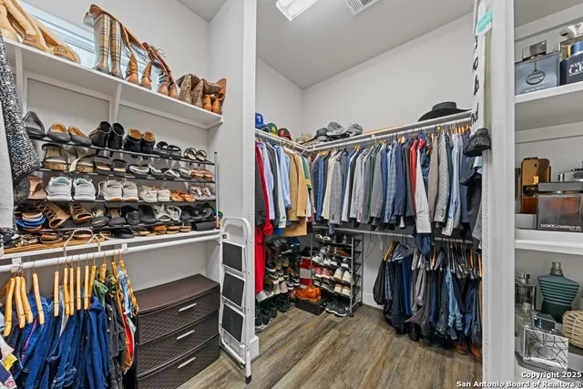 a view of walk in closet with clothes and shoes