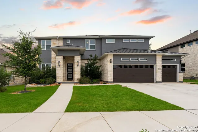 a front view of a house with a yard and trees