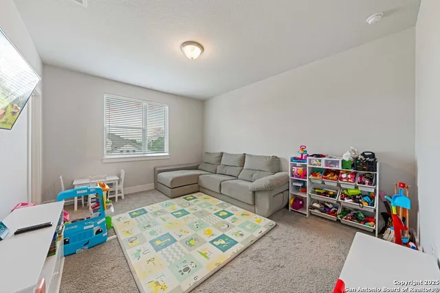 a living room with furniture and a baby crib