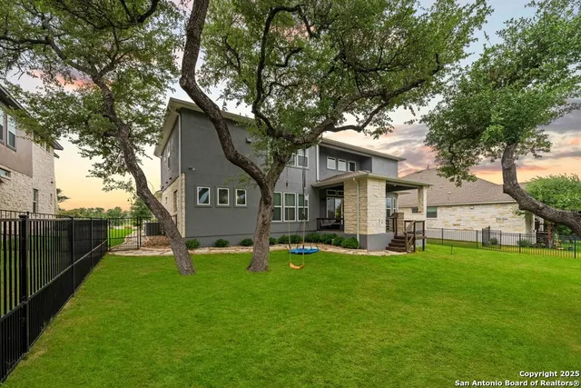 a view of a house with a yard potted plants and a large tree