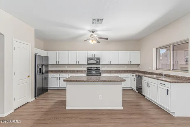 a kitchen with a stove sink and cabinets