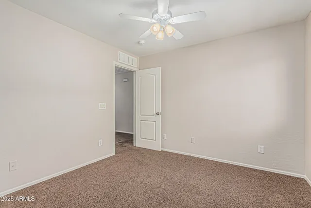 an empty room with a ceiling fan and a window