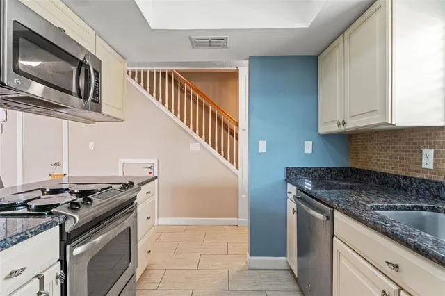 a kitchen with stainless steel appliances granite countertop a stove and a microwave