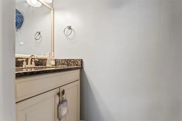 a bathroom with a granite countertop sink and vanity