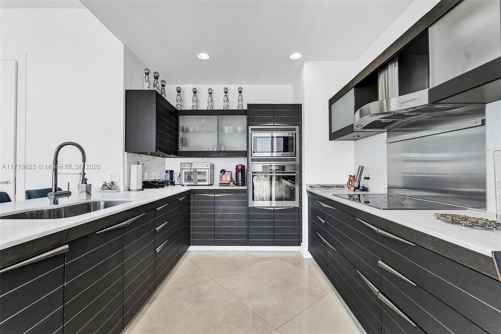 200 Biscayne Blvd Way, Unit 5001 Miami, FL 33131 - Photo 8 of 48 a kitchen with kitchen island granite countertop a sink stainless steel appliances and cabinets