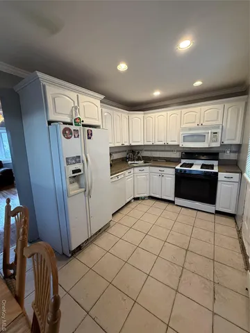 a kitchen with granite countertop a refrigerator and a stove top oven