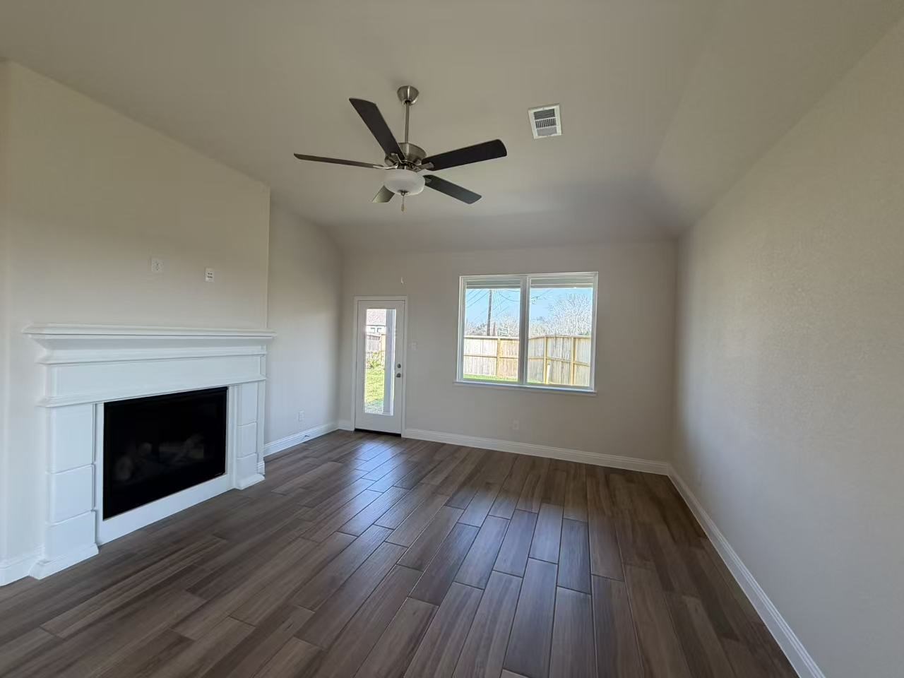 4014 Colony Lane Missouri City, TX 77459 - Photo 21 of 40 an empty room with wooden floor fireplace and windows