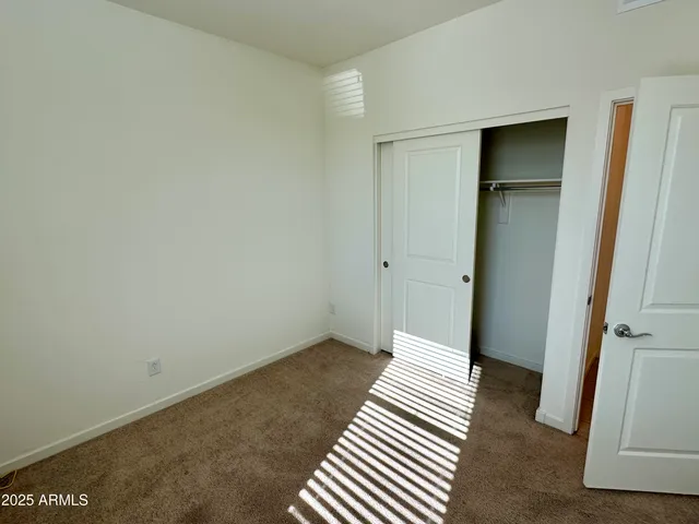 a view of a room with wooden floor and a bathroom