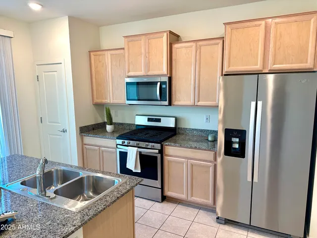 a kitchen with granite countertop a refrigerator and a sink