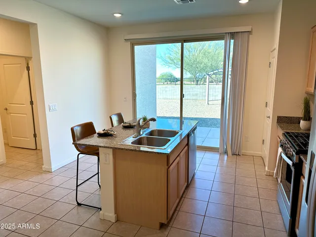 a kitchen that has a sink a stove and a refrigerator