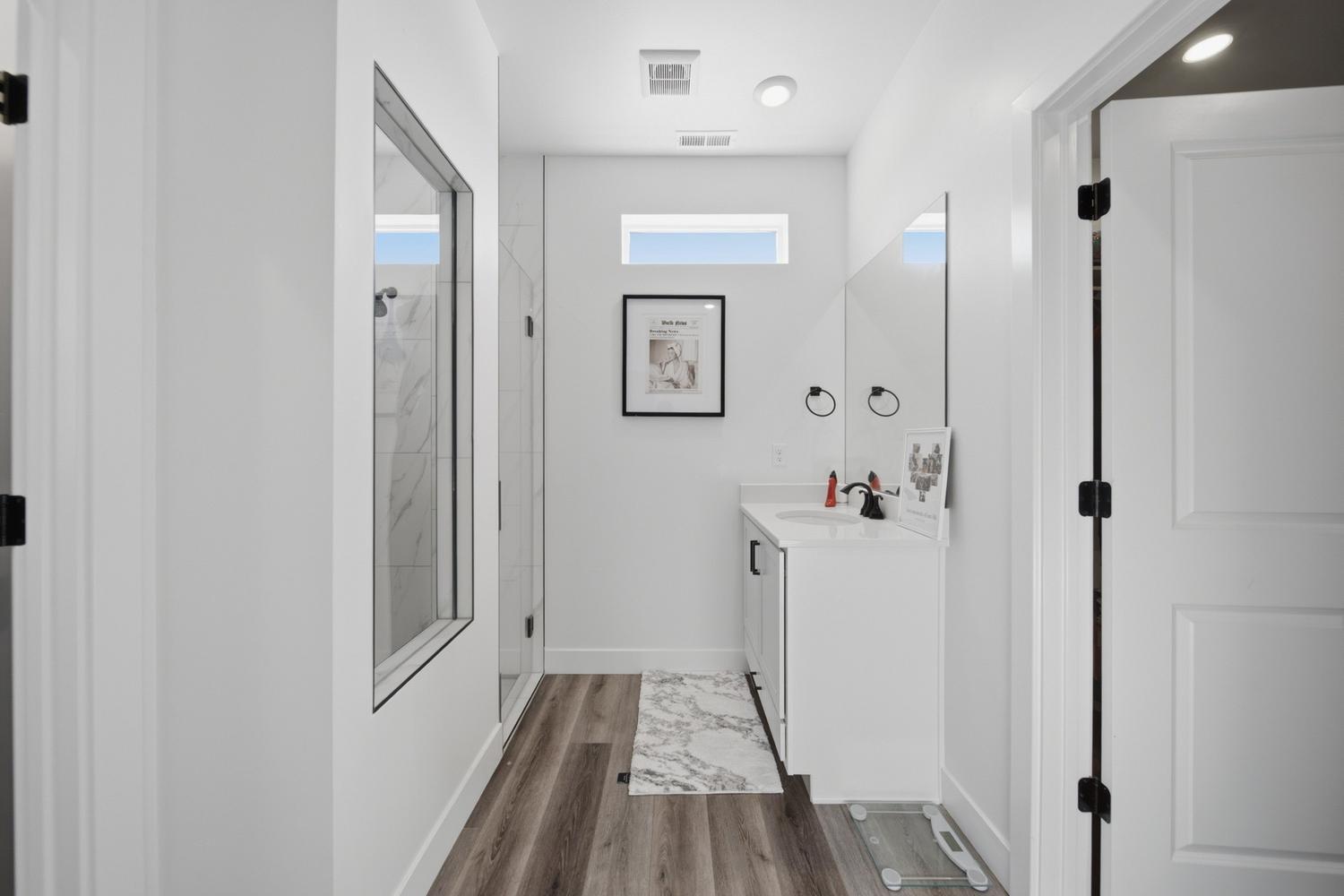 6144 Red Sand Lane St. George, UT 84790 - Photo 10 of 19 A compact yet stylish powder area rounds out this level, featuring a wall-mounted vanity, sleek matte-black fixtures, and a mirror that reflects soft light from the adjacent window. Every inch here is designed with efficiency, privacy, and understated style in mind.
