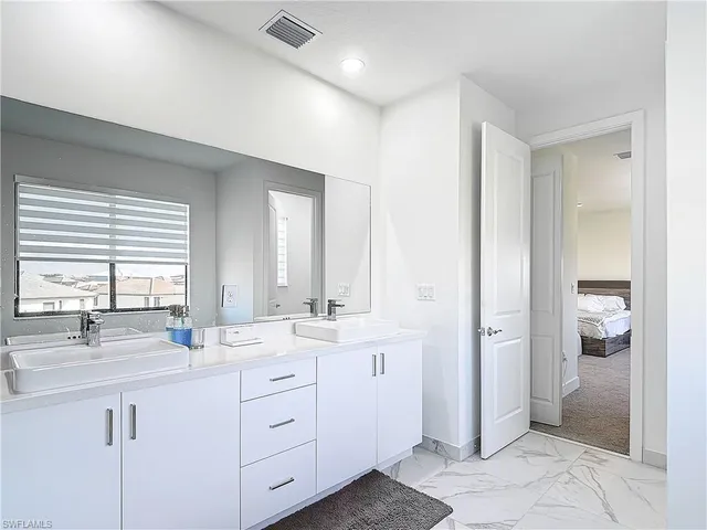 a bathroom with double sink and a mirror