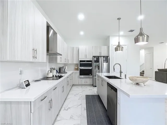 a kitchen with counter top space a sink stainless steel appliances and cabinets