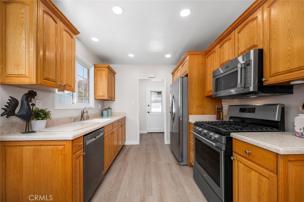 3819 North Studebaker Road Long Beach, CA 90808 - Photo 12 of 62 The kitchen showcases handsome oak cabinetry complemented by sleek Corian countertops for a classic yet practical design.