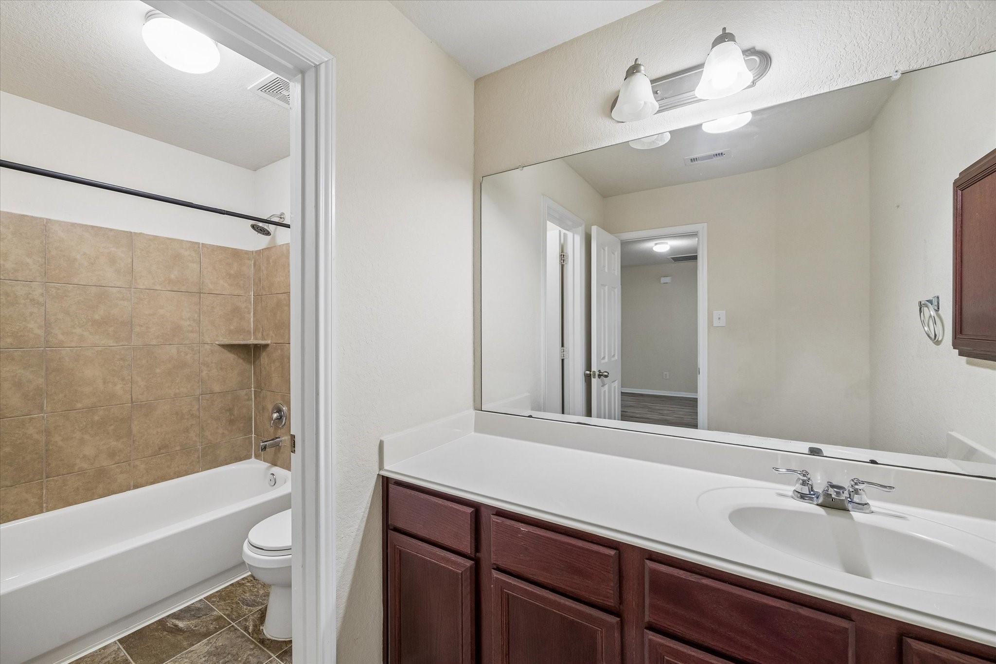 15642 South Fall Fern Circle Houston, TX 77044 - Photo 29 of 32 a bathroom with a sink a toilet a mirror a bathtub and shower