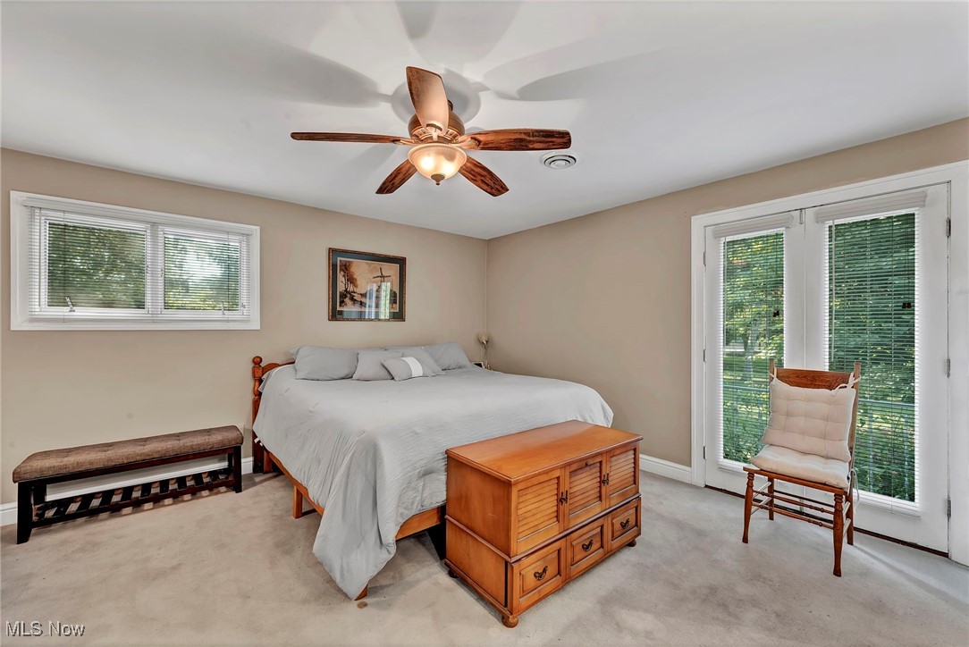 25915 Kennedy Ridge Road North Olmsted, OH 44070 - Photo 25 of 48 Bedroom featuring multiple windows, access to exterior, light carpet, and a ceiling fan
