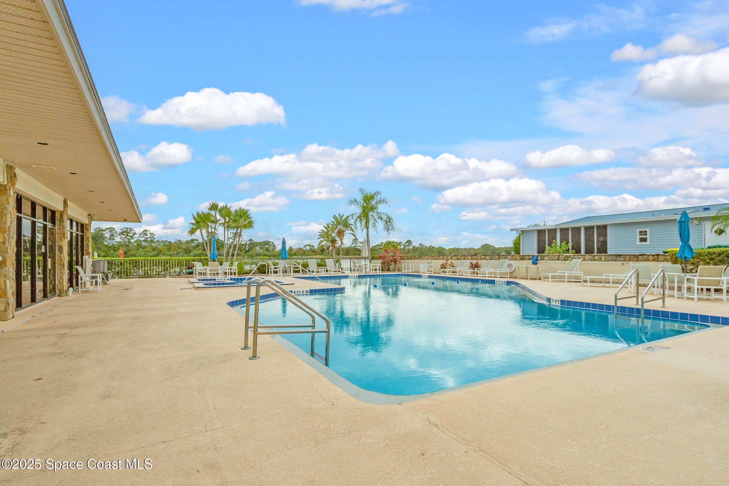 595 Outer Drive, Unit 129 Cocoa, FL 32926 - Photo 32 of 49 a view of a swimming pool with a lounge chair
