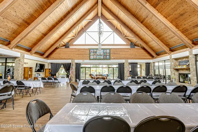 a view of a dining hall with lots of furniture and wooden floor