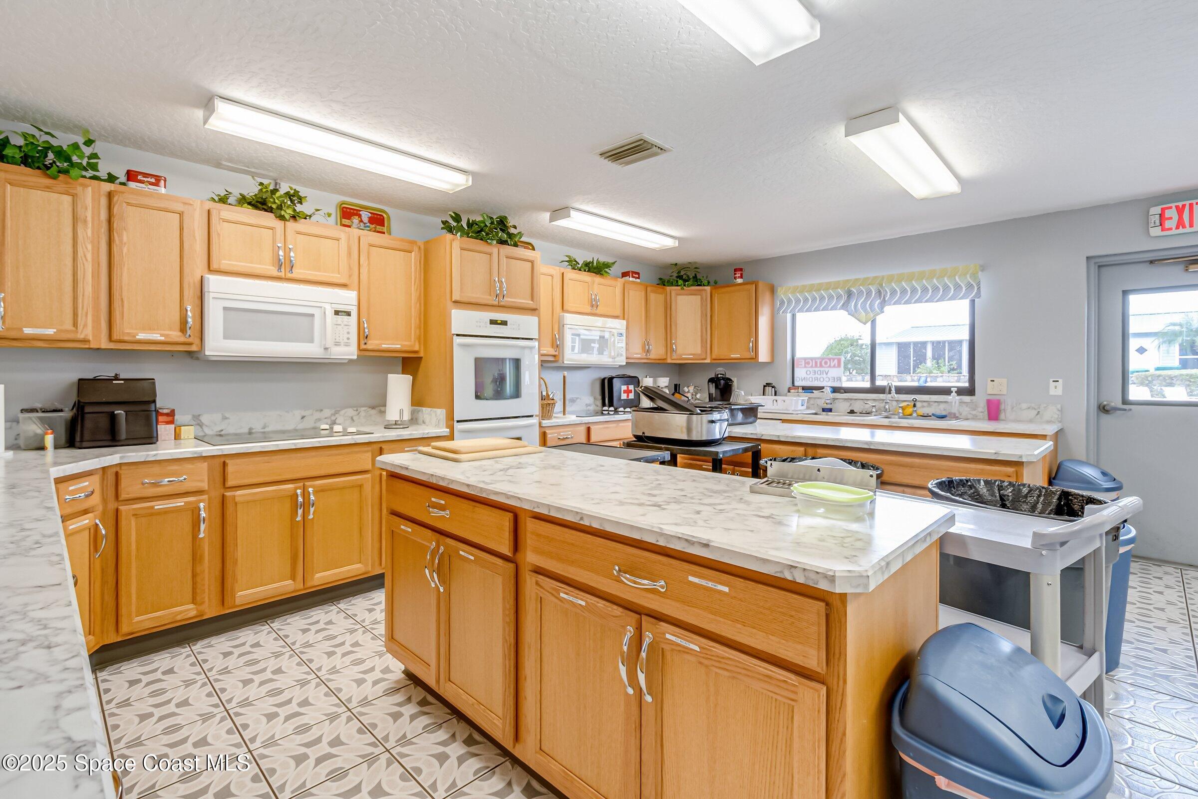 595 Outer Drive, Unit 129 Cocoa, FL 32926 - Photo 41 of 49 a kitchen with stainless steel appliances granite countertop a stove a sink and a refrigerator