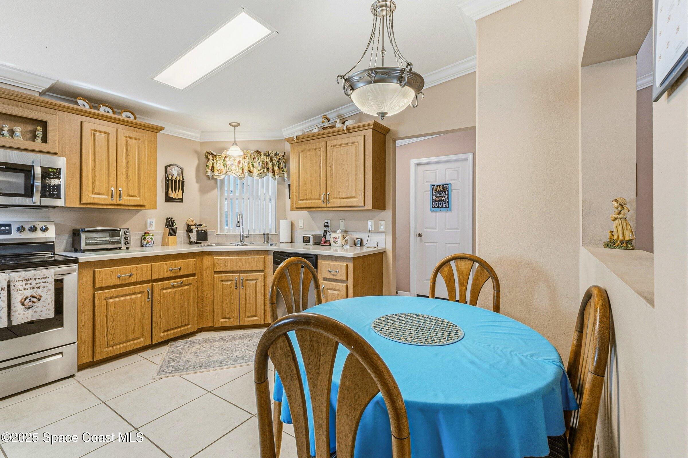 595 Outer Drive, Unit 129 Cocoa, FL 32926 - Photo 8 of 49 a kitchen with stainless steel appliances a sink a stove a refrigerator cabinets and a dining table