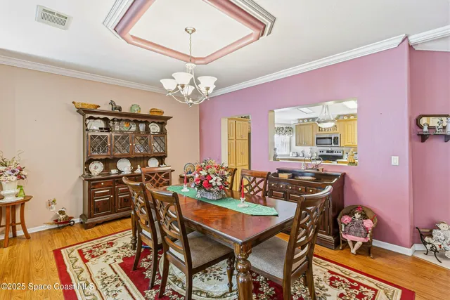 a view of a dining room with furniture a chandelier and wooden floor