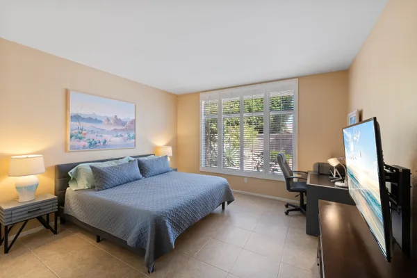 a spacious bedroom with a bed a couch and a large window