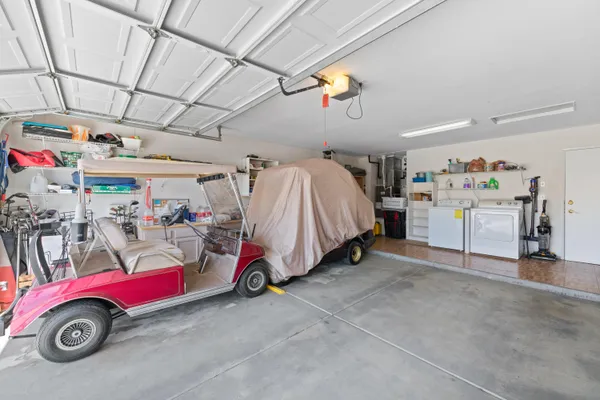 a view of parking space with a garage and washing machine