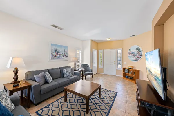 a living room with furniture a flat screen tv and a window