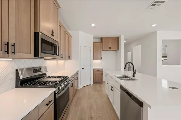 a kitchen with a sink stove and cabinets