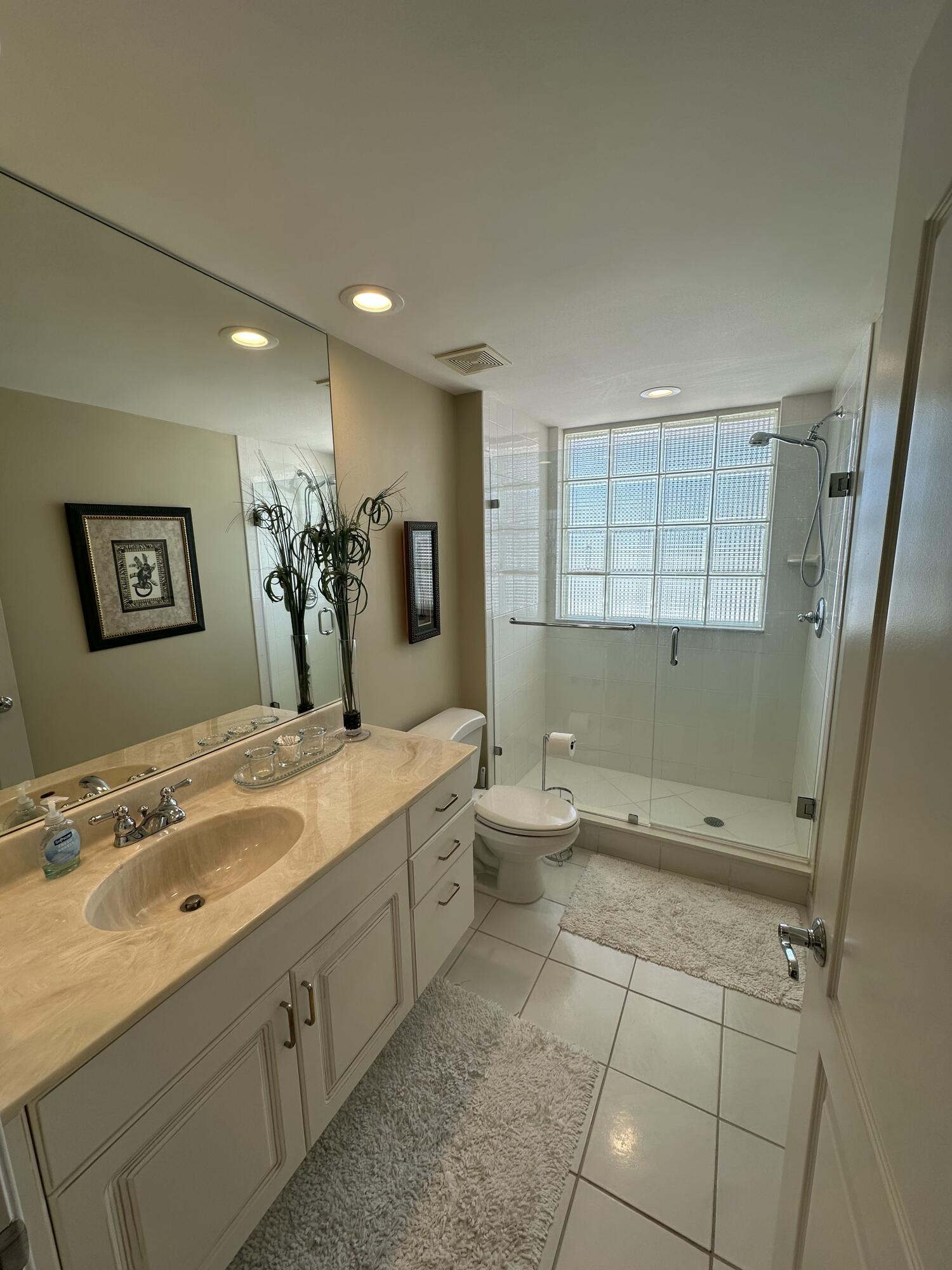 2900 North Hwy A1A, Unit 2 Fort Pierce, FL 34949 - Photo 18 of 34 a spacious bathroom with a granite countertop sink a toilet and a mirror