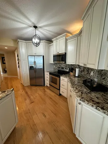 a kitchen with stainless steel appliances granite countertop a stove a sink and a refrigerator