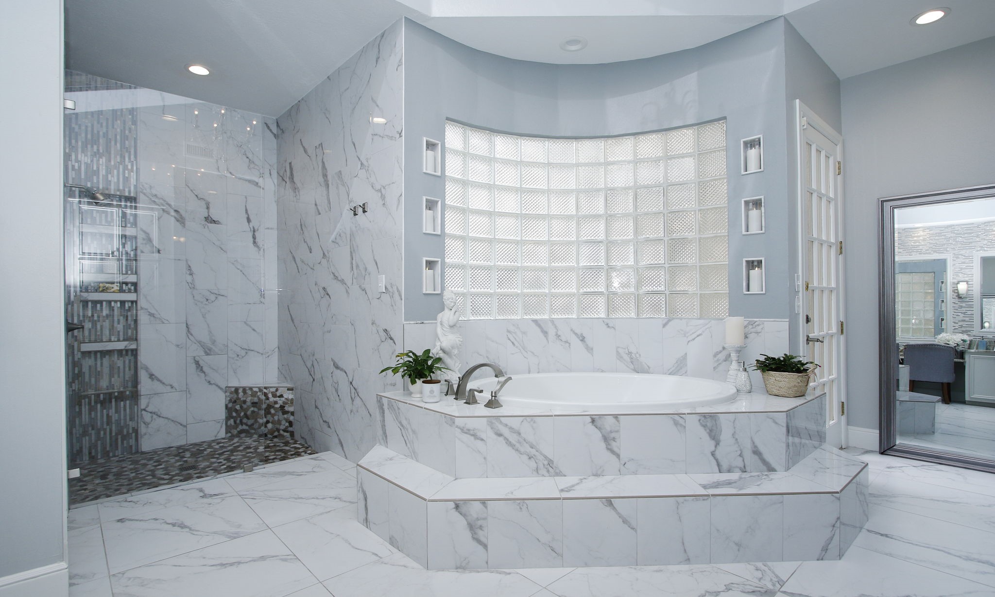 16610 Manningtree Lane Spring, TX 77379 - Photo 19 of 50 The tub is the focal point of the primary bathroom with glass brick that allow for natural lighting.