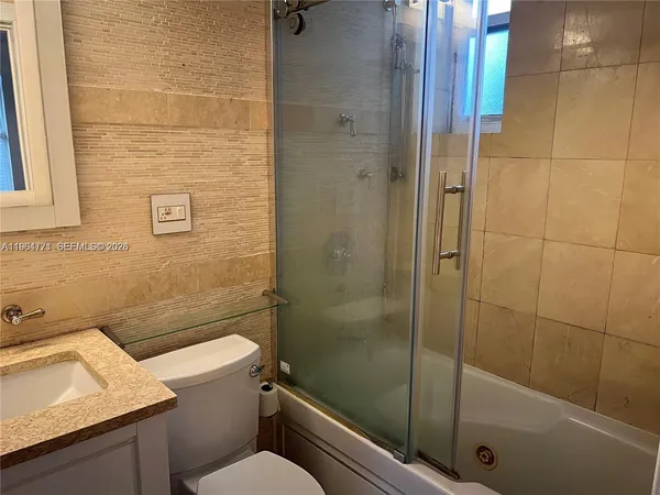 a bathroom with a shower a toilet and sink
