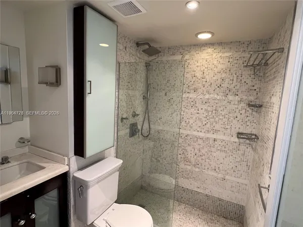 a bathroom with a shower toilet and sink
