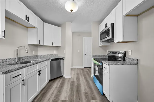 a kitchen with stainless steel appliances granite countertop a sink and stove top oven