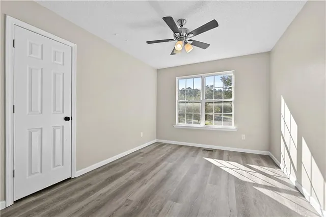 a view of a livingroom with a window and wooden floor