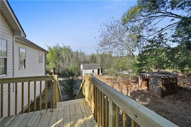 a view of a wooden deck and trees in the background