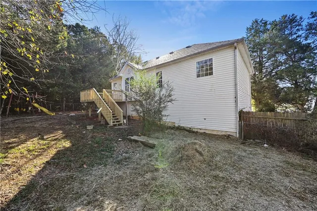 a view of a backyard with plants and large tree