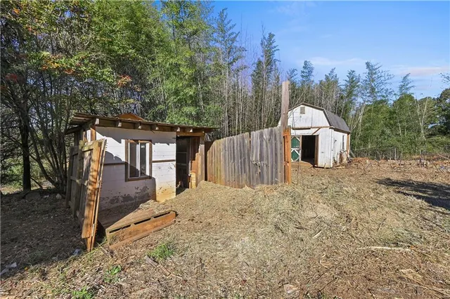 a view of a house with backyard and trees