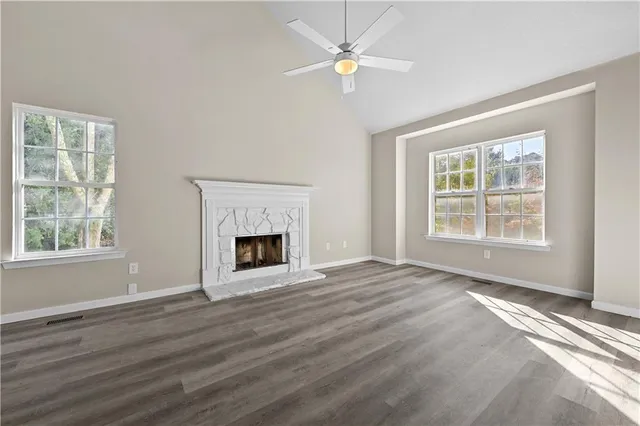 wooden floor fireplace and windows in an empty room