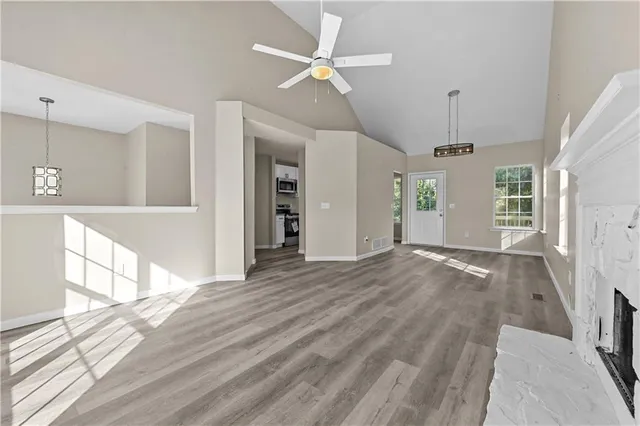 a view of an empty room with window and wooden floor